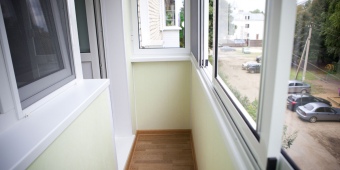 Холодное остекление балкона с обшивкой пластиковыми панелями.